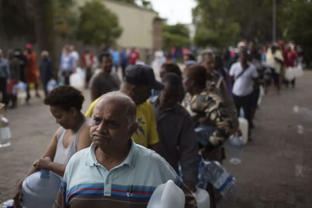 Residents of Cape Town, South Africa, wait in line for water. (Image courtesy of AP Photo/Bram Janssen.)