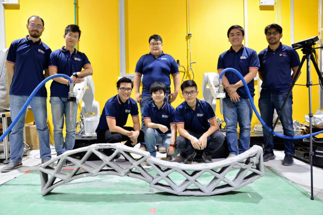 A team of researchers, led by NTU’s Assistant Professor Pham Quang Cuong, show off the structure their robots printed. (Image courtesy of NTU Singapore.)