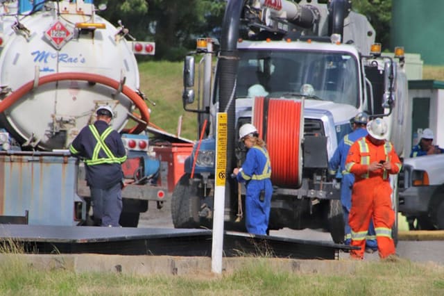 Workers recovering oil after a spill in Abbotsford, B.C. (Picture courtesy of The Abbotsford News.)
